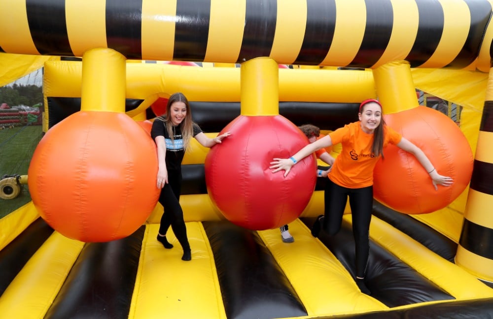 Energiser Two people play on an inflatable obstacle course with large hanging balls.