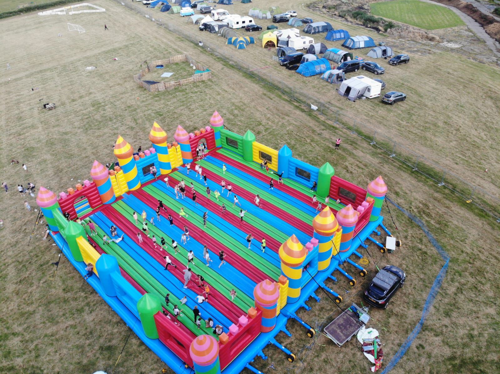 Two people climbing a colorful inflatable ladder inside a play structure.