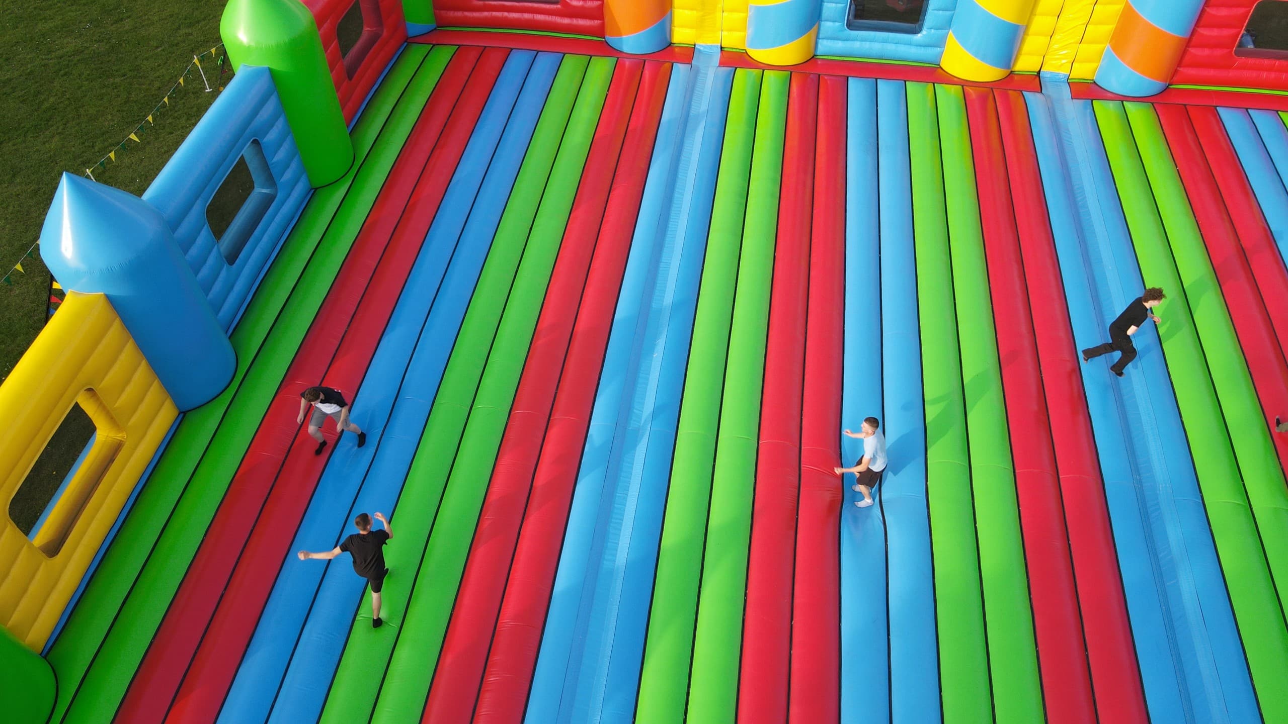 Lab Tour 55 Aerial view of a large colorful inflatable obstacle course set up on a grassy field.