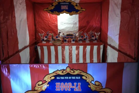 A red and white striped fair stall for the Hoopla ring toss game.