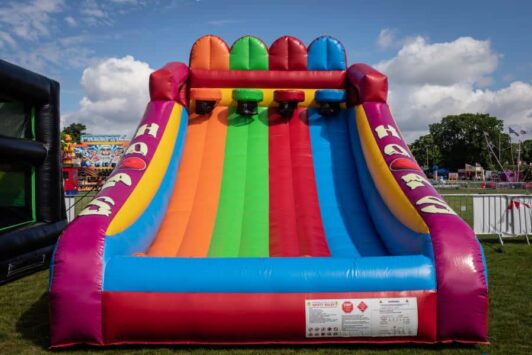 Inflatable four-lane basketball shootout game with colorful lanes at an outdoor event.