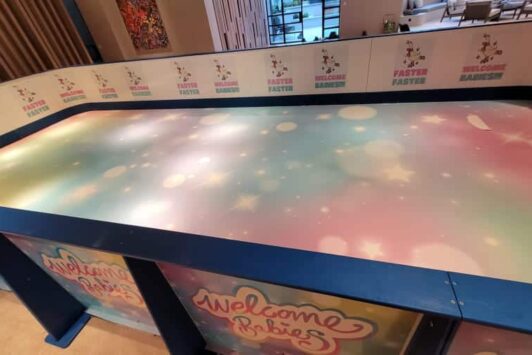 Colorful play area with "Welcome Babies" branding and playful, pastel-themed event decorations.