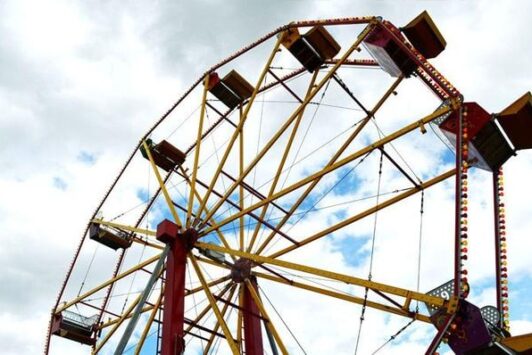 A colorful ferris wheel against a cloudy sky.